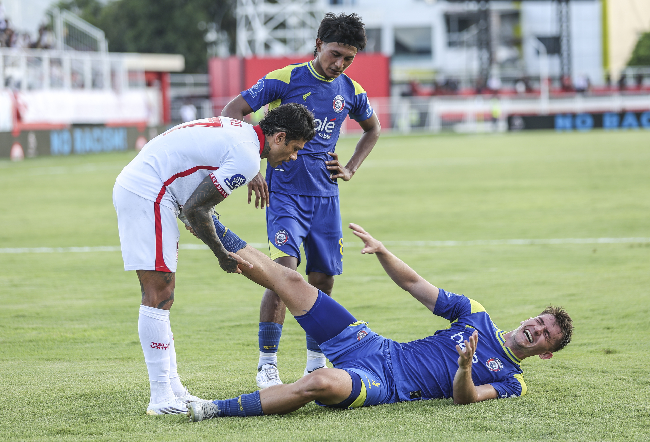 Pesepak bola Malut United Ciro Henrique Alves Ferreira E Silva (kiri) membantu meregangkan kaki pesepak bola Arema Fc Odivan Koerich (kanan) pada pertandingan BRI Super League di Stadion Gelora Kie Raha Ternate, Maluku Utara, Sabtu (29/11/2025). Pertandingan tersebut berakhir imbang dengan skor 1-1.