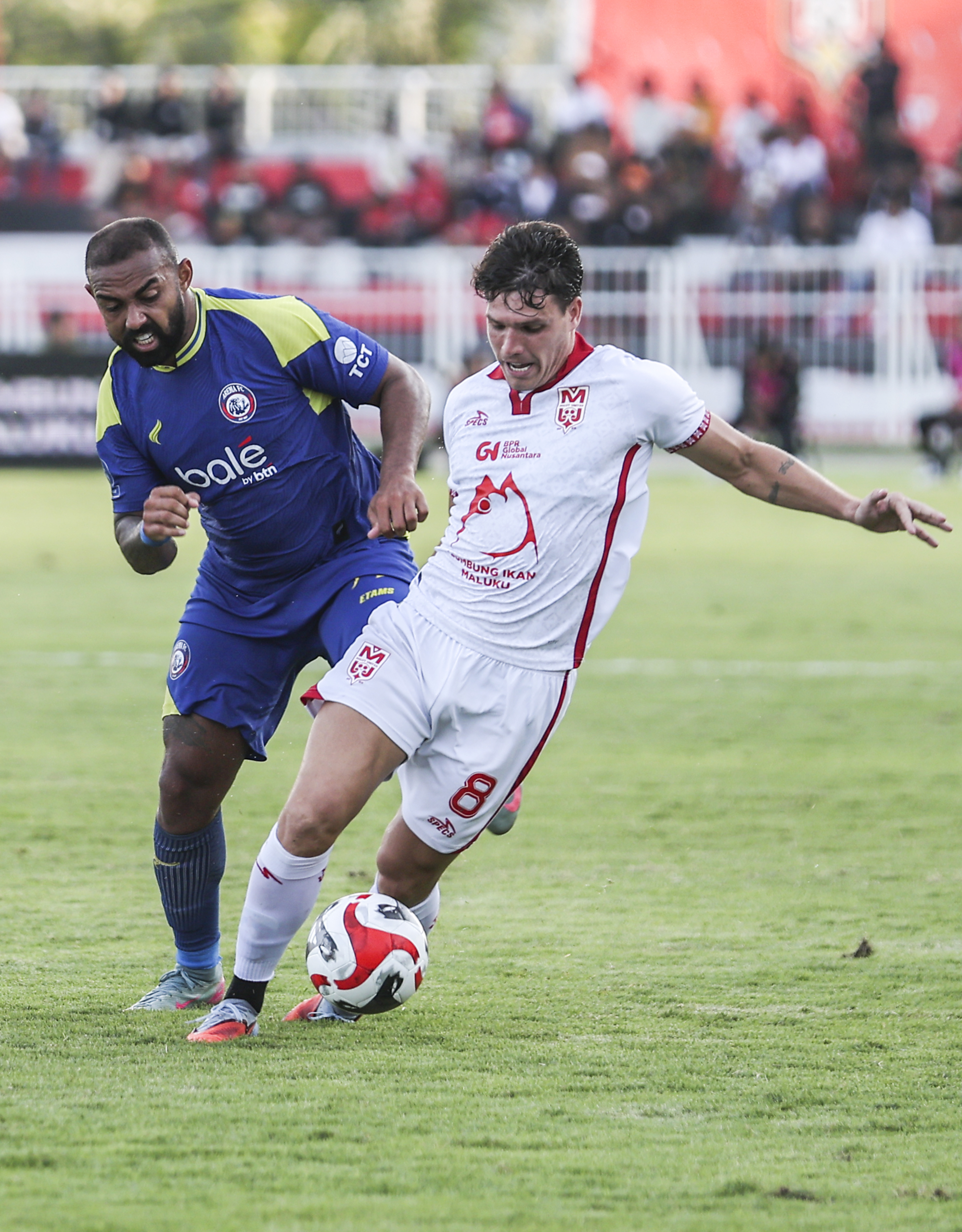 Pesepak bola Malut United Vinicius Duarte (kanan) berebut bola dengan pesepak bola Arema FC Dalberto Luan Belo (kiri) pada pertandingan BRI Super League di Stadion Gelora Kie Raha Ternate, Maluku Utara, Sabtu (29/11/2025). Pertandingan tersebut berakhir imbang dengan skor 1-1.